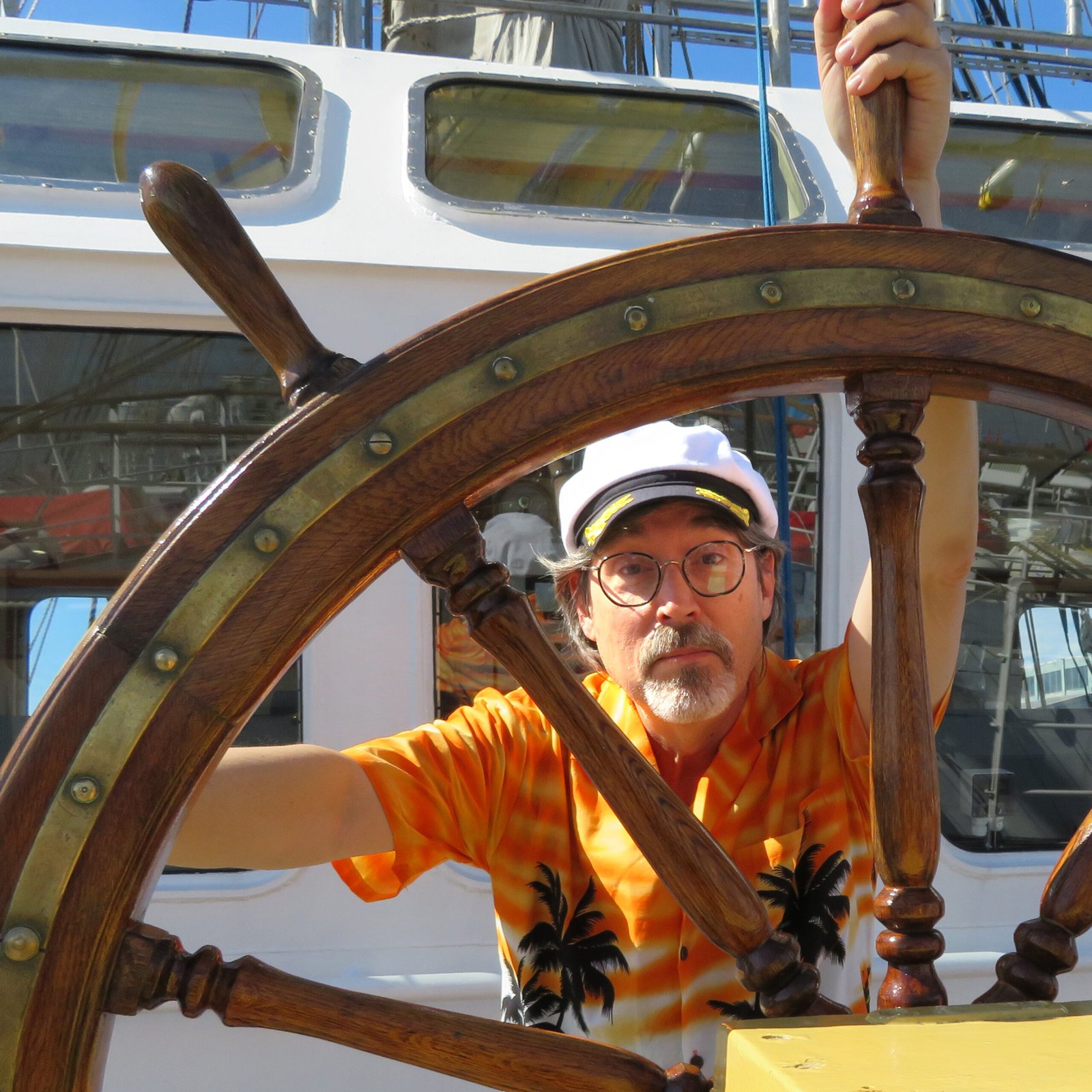 Robert Palomo behind a ship's wheel